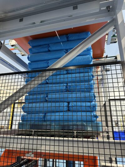 Blauwe zakken worden op een pallet gestapeld door de Marfil palletiser, bij het bedrijf Snebo